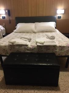 łóżko z kwiatową narzutą i ręcznikami w obiekcie Hotel Giordano Spiaggia w Rimini