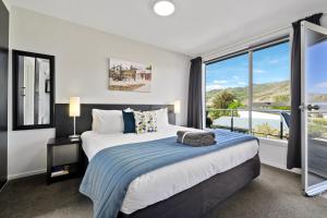 a bedroom with a bed and a large window at Central Gateway Motel in Cromwell