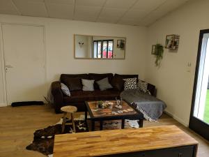 a living room with a couch and a coffee table at Dépendance chaleureuse dans le vignoble nantais in La Haie-Fouassière