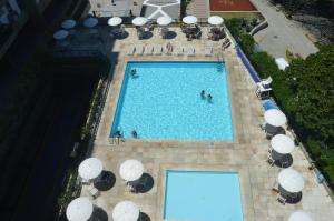 una vista aérea de una piscina con sombrillas en BarraBella Apartamentos, en Río de Janeiro