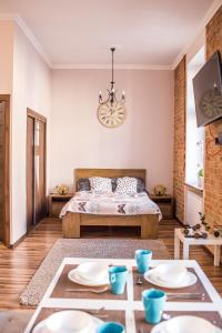 Un dormitorio con una cama y una mesa con platos. en Voal Apartamenty, en Lublin