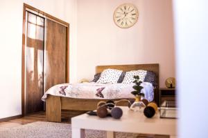 1 dormitorio con 1 cama y reloj en la pared en Voal Apartamenty, en Lublin