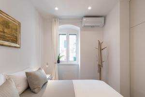 a white bedroom with a bed and a window at Adriatik Lux Teatro 2 in Split