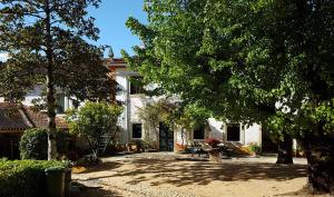 a large white house with trees and a yard at Quinta da Bizelga Cottages in Tomar