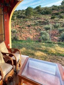 a screened in porch with a glass table and chairs at Valley Views Full House Stargazing in Valencia in Ayora