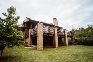 una casa grande con columnas de ladrillo en un patio en Magia en Sierra de la Ventana