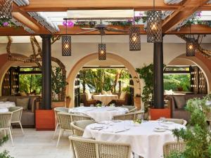 an outdoor restaurant with white tables and chairs at Hotel Bel-Air - Dorchester Collection in Los Angeles