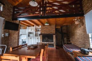 Un comedor con mesa y chimenea. en Los Catires, en Sierra de la Ventana