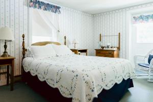 een slaapkamer met een groot bed en een raam bij Carriage Barn Inn in Keene