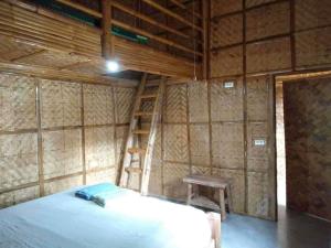 Habitación con cama, escalera y taburete en Calayo Beach Resort, en Nasugbu