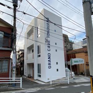 un bâtiment blanc avec un panneau sur son côté dans l'établissement GRAND CAVE YOKOHAMA, à Yokohama