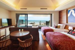 a hotel room with two beds and a table at THE HIRAMATSU HOTELS & RESORTS GINOZA OKINAWA in Ginoza