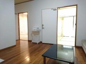a living room with a glass table and a door at Kokusai Towns Inn in Naha +50 photos