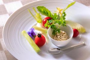 a white plate with vegetables and a bowl of food at THE HIRAMATSU HOTELS & RESORTS GINOZA OKINAWA in Ginoza