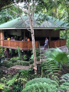 a group of people sitting on a porch of a house at Pulangbato Falls Mountain Resort in Dumaguete