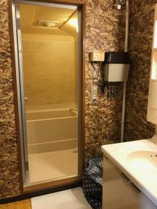 ein Badezimmer mit einer Dusche, einem Waschbecken und einer Badewanne in der Unterkunft Hokkaido Bed & Bagel in Eniwa