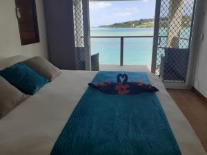 una cama con una flor con vistas al océano en Moorings Hotel en Port Vila