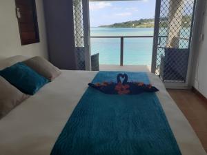 فندق مورينجس في بورت فيلا: سرير عليه زهرة مطلة على المحيط