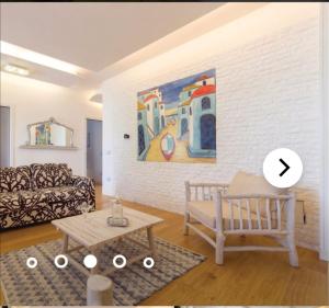 - un salon avec un canapé et un tableau mural dans l'établissement Villa Puccio, à Castelvetrano