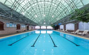 a large swimming pool with a glass ceiling at Maison New Century Hotel Ningbo in Ningbo