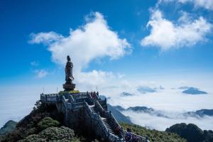 a statue on top of a mountain with clouds at My Dream Hotel in Sapa