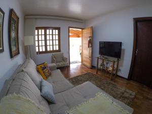 a living room with a couch and a television at Corona Hostel in Poços de Caldas