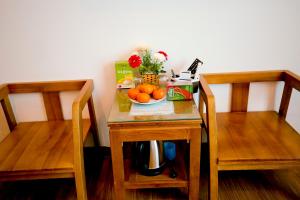 stół z miską pomarańczy i pudełkiem. w obiekcie Việt Anh Hotel w mieście Ninh Binh