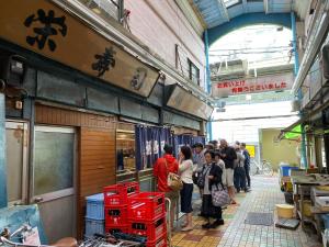 a group of people standing outside of a store at HOTEL Japonica in Tokyo