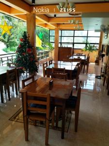 a restaurant with tables and chairs and a christmas tree at West Atlantic Inn in Concepcion