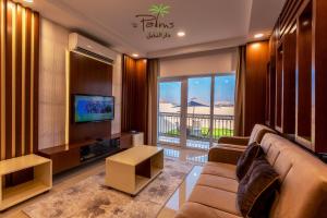 a living room with a couch and a television at Palms Residence Inn دار النخيل in Nizwa