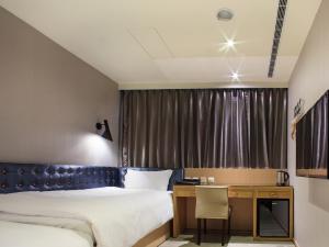 a hotel room with two beds and a desk at Stay Hotel - Taichung Yizhong in Taichung