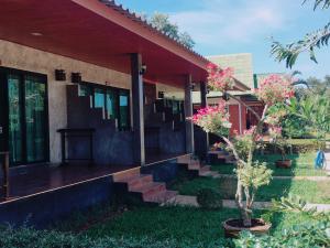 une maison avec des escaliers et des fleurs dans l'herbe dans l'établissement Lanta Queen Resort, à Ko Lanta