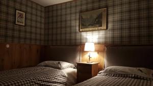 a hotel room with two beds and a lamp at Appartamenti dei Giardini in Courmayeur