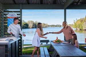 a group of people standing around a picnic table at Discovery Parks - Forster in Tuncurry