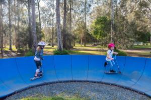 two young girls riding on a trampoline at Discovery Parks - Forster in Tuncurry