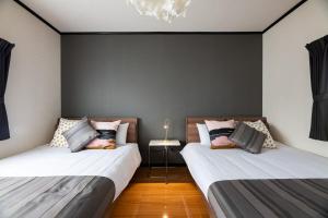 two beds in a room with black walls at Hana Azusa in Yufuin