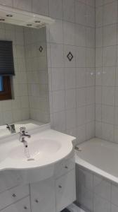 La salle de bains est pourvue d'un lavabo, d'une baignoire et d'un miroir. dans l'établissement Ferienwohnung Wohlesser, à Annaberg-Lungötz