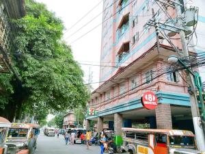 a busy city street with buses and people on the street at 8Hostel in Manila