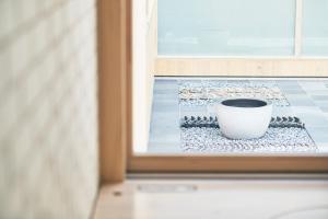 a white cup sitting on a window sill at Shonai Hotel Suiden Terrasse in Tsuruoka