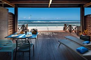 una sala da pranzo con tavolo e vista sull'oceano di T2B Lagon Austral "parenthèse australe" a Saint-Pierre