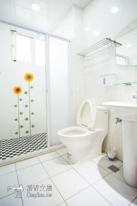 a bathroom with a toilet and a sink and a shower at Chishang Daoxiang Hotel in Chishang