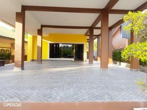 an empty courtyard of a building with yellow walls and columns at G-HAN Residence in Nai Yang Beach +11 photos