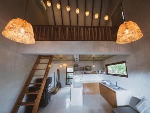 a kitchen with a staircase and two chandeliers at Little Ripper Boutique Loft Studio in Tanah Lot