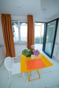 un soggiorno con un tavolo giallo e fiori di Blu Ravello a Ravello