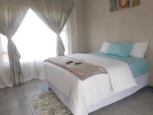 - une chambre avec un grand lit et une fenêtre dans l'établissement Jubie's Guest Lodge, à Vereeniging