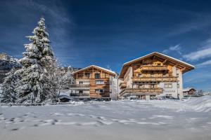 una baita di tronchi nella neve con un albero di Natale di Tlisüra a La Villa
