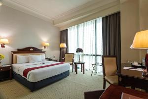 宿霧市的住宿－Sarrosa International Hotel and Residential Suites，酒店客房设有一张大床和一张书桌。