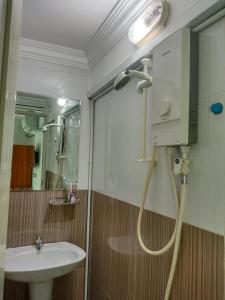 uma casa de banho com um chuveiro e um lavatório. em Le Barang Steakhouse & Guesthouse em Sihanoukville