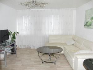 ein Wohnzimmer mit einem weißen Sofa und einem Tisch in der Unterkunft Ferienwohnung Volskyy in Trier