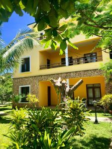 a building with a palm tree in front of it at Flametree Beach Homes in Diani Beach